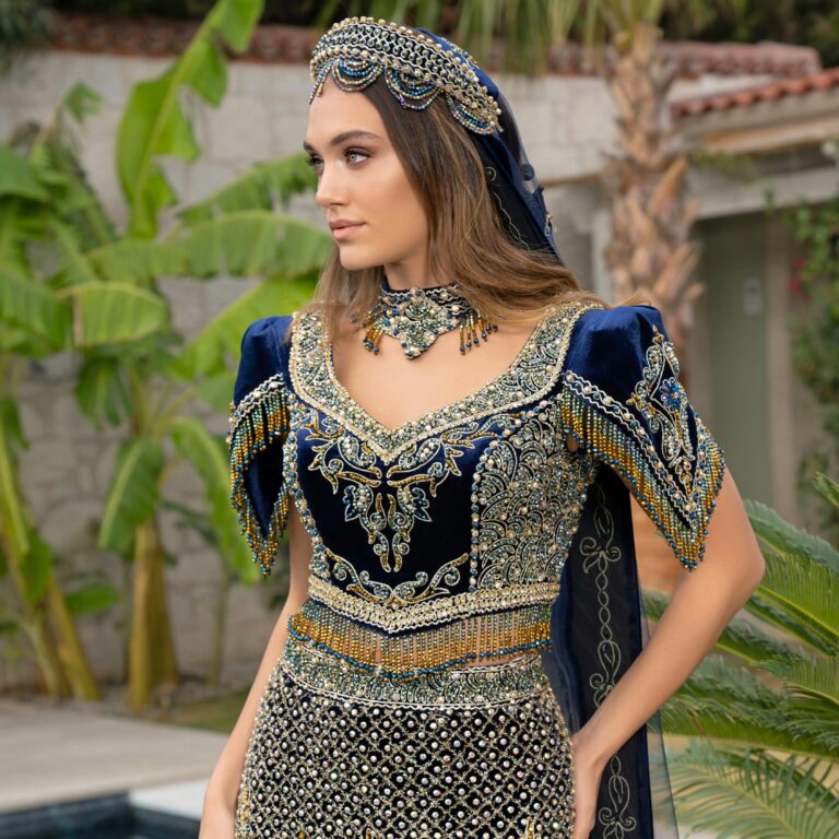 A woman in a richly embroidered traditional Turkish dress, outdoors in İzmir.